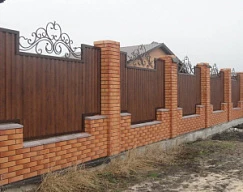 Забор на кирпичных столбах из профнастила под дерево с кованными деталями